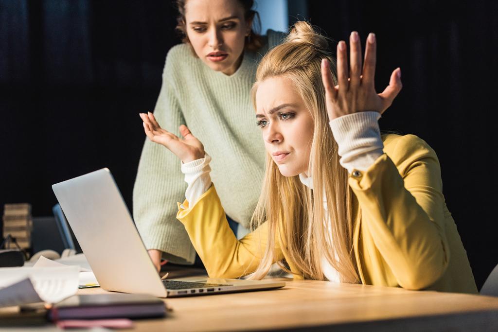 beautiful confused female it specialists using laptop in office - Photo, Image
