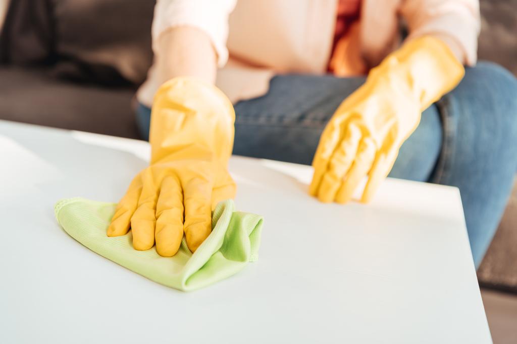 Περικοπεί άποψη της γυναίκας σε κίτρινα γάντια καθαρισμού πίνακα με πανί - Φωτογραφία, εικόνα