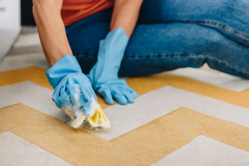 Cropped view of woman in blue rubber gloves cleaning carpet - Photo, Image