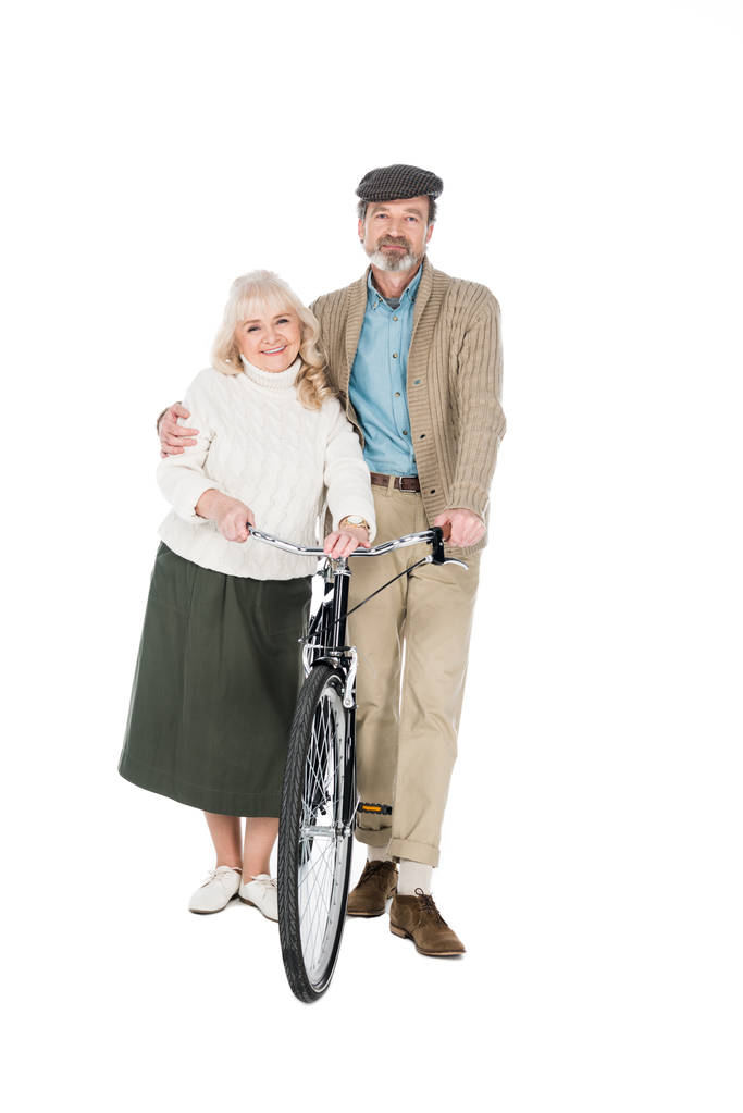 alegre aposentado abraçando esposa enquanto segurando bicicleta isolada no branco
 - Foto, Imagem