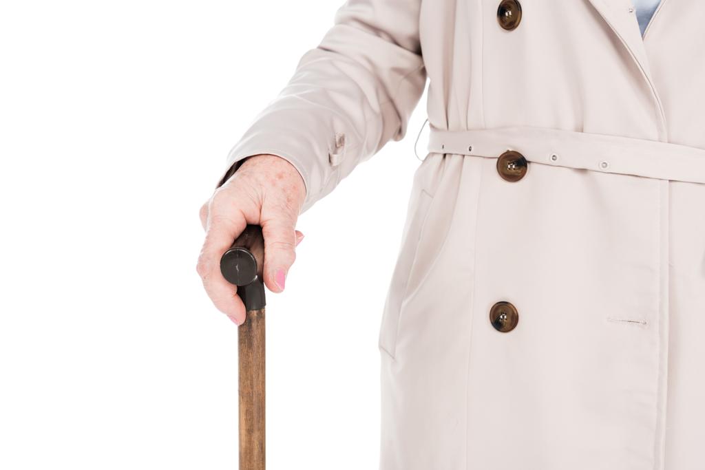白で隔離の杖を保持している年配の女性のトリミング ビュー - 写真・画像