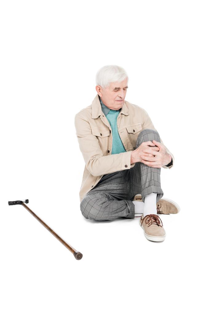 Rentner hält Knie, während er Arthritis-Schmerzen isoliert auf weiß hat - Foto, Bild