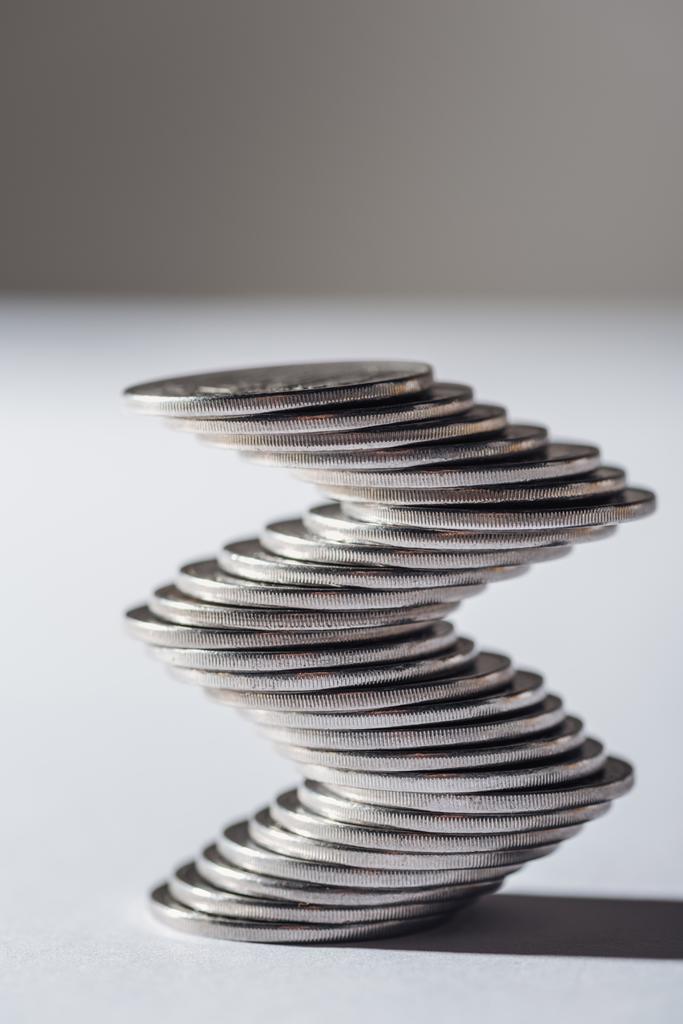 pilha de moedas de prata curvo no fundo cinza borrado
 - Foto, Imagem
