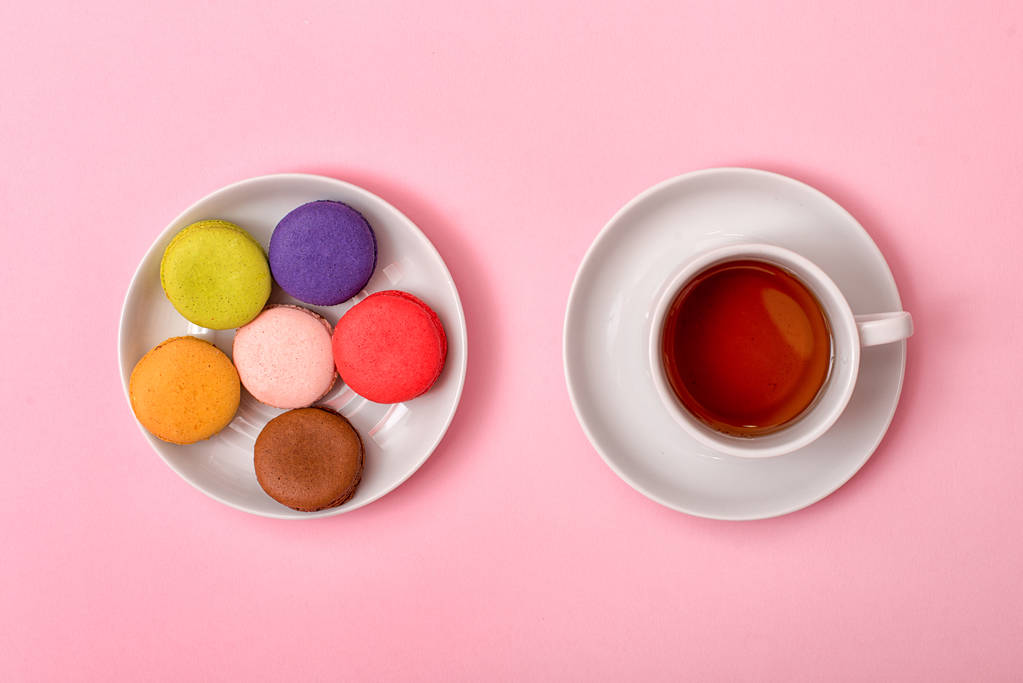 Macaron dolci colorati e una tazza di tè. Deliziosa colazione. Vista dall'alto
. - Foto, immagini