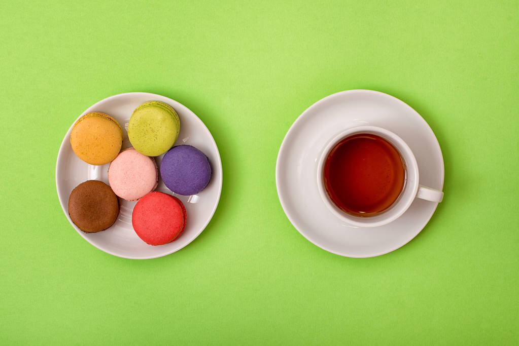 Macaroons doces coloridos e uma xícara de chá. Delicioso pequeno-almoço. Vista superior
. - Foto, Imagem