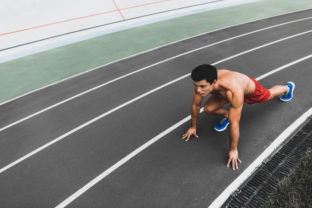 Сосредоточенный голый мужчина готовится к бегу на свежем воздухе
 - Фото, изображение