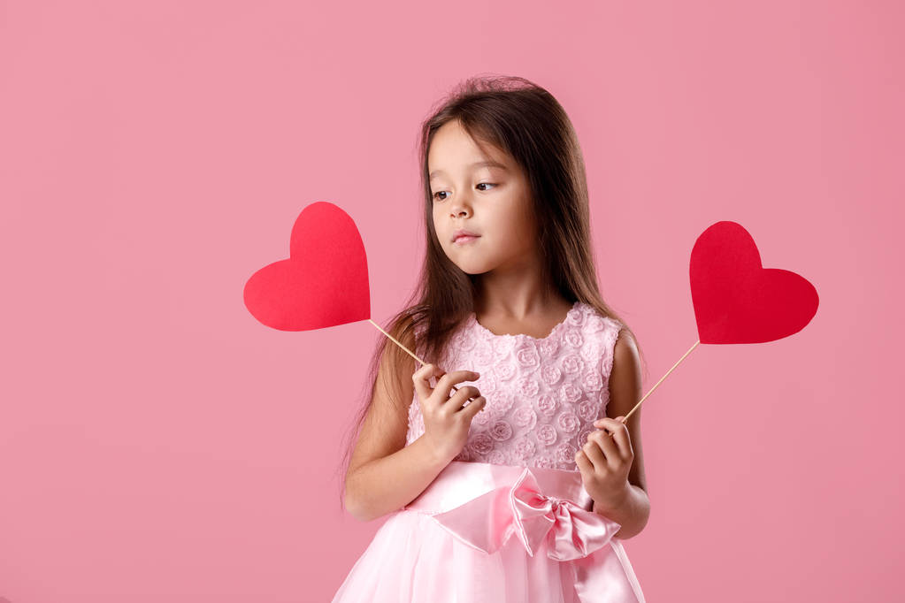 linda niña en un vestido rosa sosteniendo un corazón de papel
 - Foto, Imagen