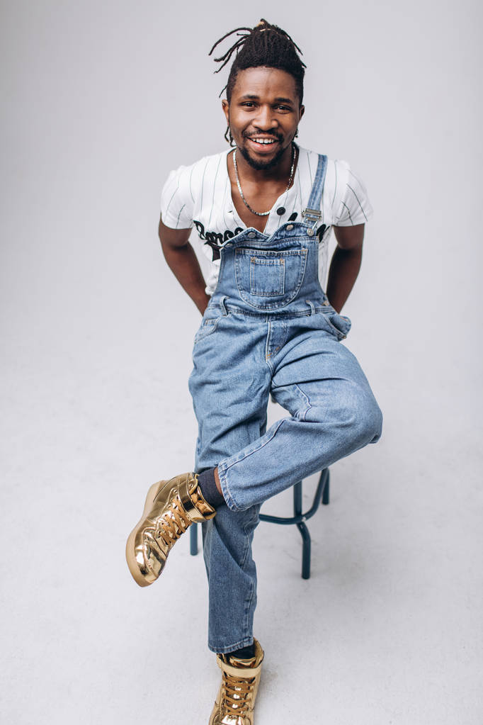 Američan Afričana na bílém pozadí v džíny a bílé tričko, emoce, emoční osoba - Fotografie, Obrázek