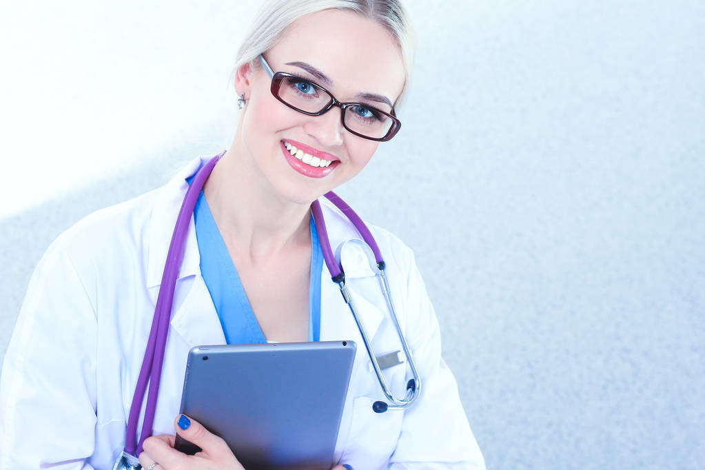 Žena lékař pomocí digitálního tabletu a stojí na bílém pozadí. Ženský doktoři. - Fotografie, Obrázek