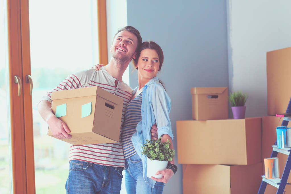 Щаслива молода пара розпаковує або упаковує коробки і переїжджає в новий будинок
. - Фото, зображення