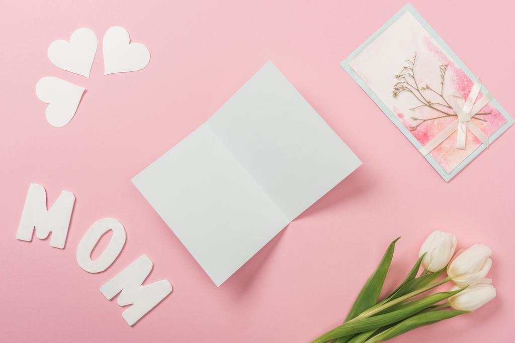mãe branca e decorada dia cartões de saudação, tulipas brancas, papéis corações e palavra mãe no fundo rosa
 - Foto, Imagem