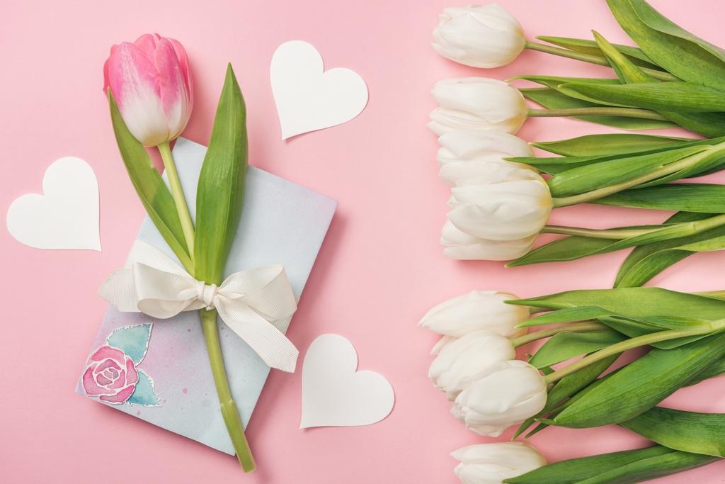 pink tulip with white bow on greeting card, paper hearts and white tulips on pink background - Photo, Image