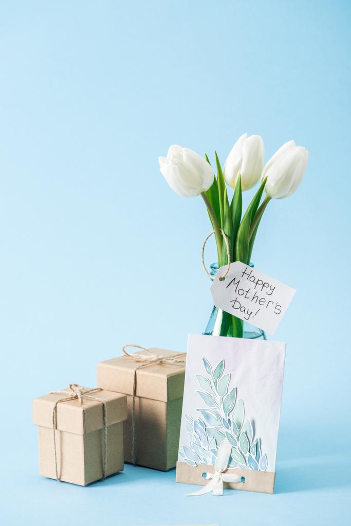 ギフト用の箱、グリーティング カード、青の背景に幸せな母の日グリーティング ラベルと白のチューリップの花束 - 写真・画像