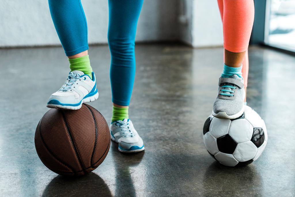 Spor ayakkabı spor salonu topları ile poz çocuklarda görünümünü kırpılmış - Fotoğraf, Görsel