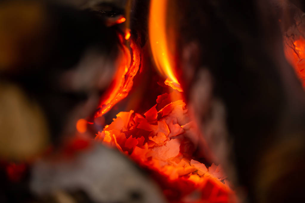 Un fuoco brucia nel camino, lentamente si produce carbone - Foto, immagini