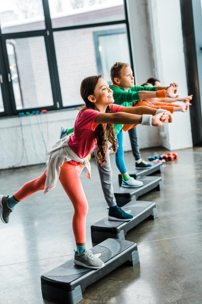 Niños haciendo ejercicios de equilibrio con plataformas escalonadas
 - Foto, Imagen