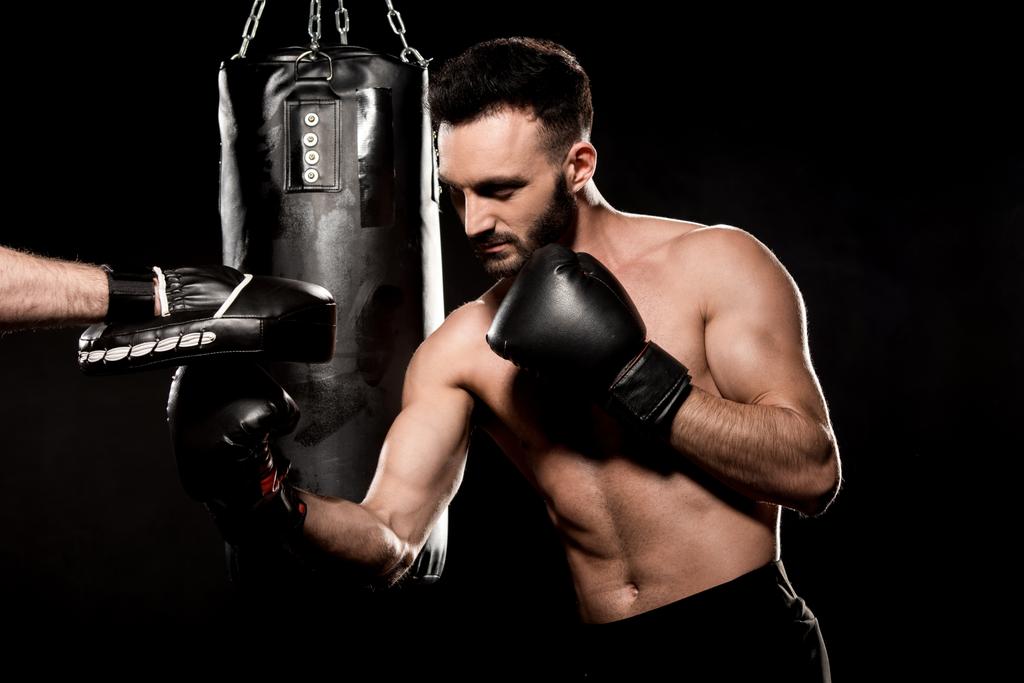 bearded boxer fighting with man in punching gloves isolated on black - Photo, Image