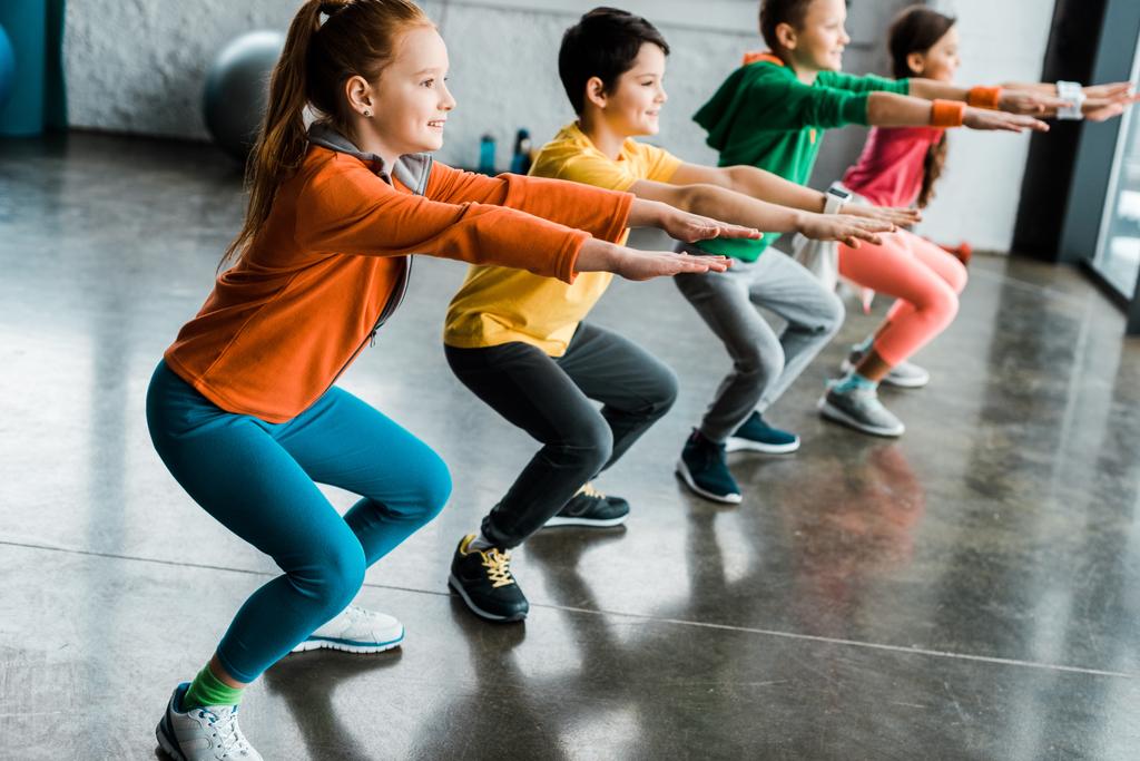 Preteen enfants faisant squats dans la salle de gym ensemble
 - Photo, image