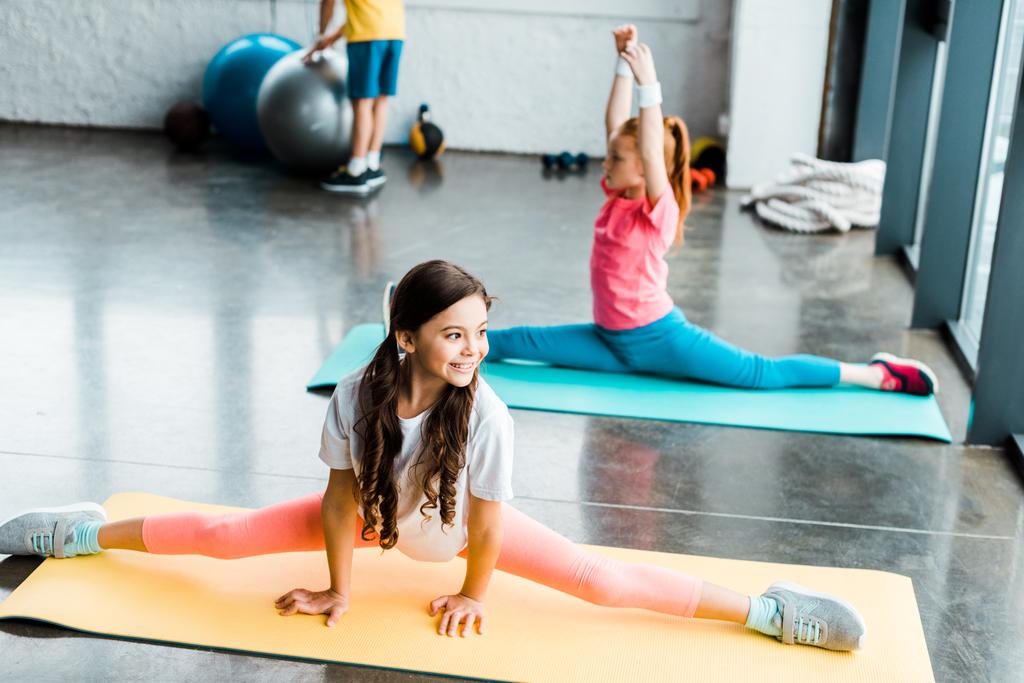 Enfants mignons faisant de la ficelle sur les tapis de fitness dans la salle de gym
 - Photo, image