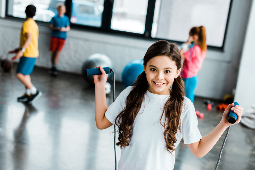 Excited brunette kid posing with skipping rope - Photo, Image