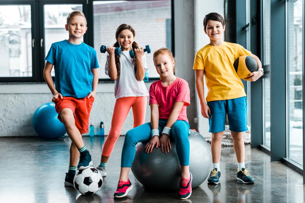 Rire enfants préadolescents posant avec des équipements de sport
 - Photo, image