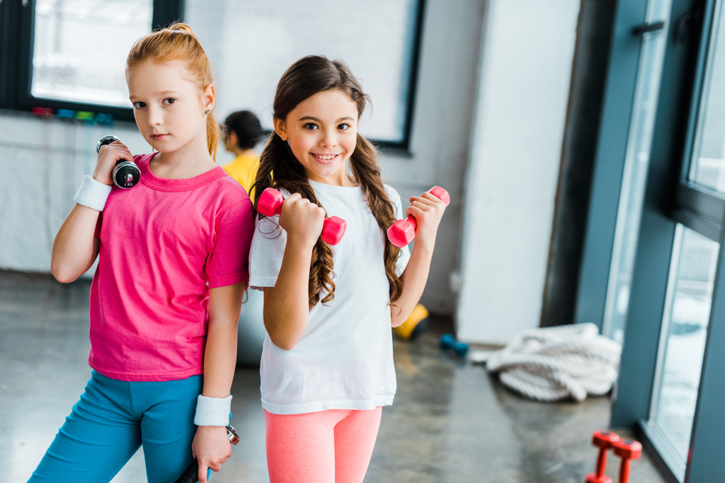 Bonito crianças posando com halteres no ginásio
 - Foto, Imagem