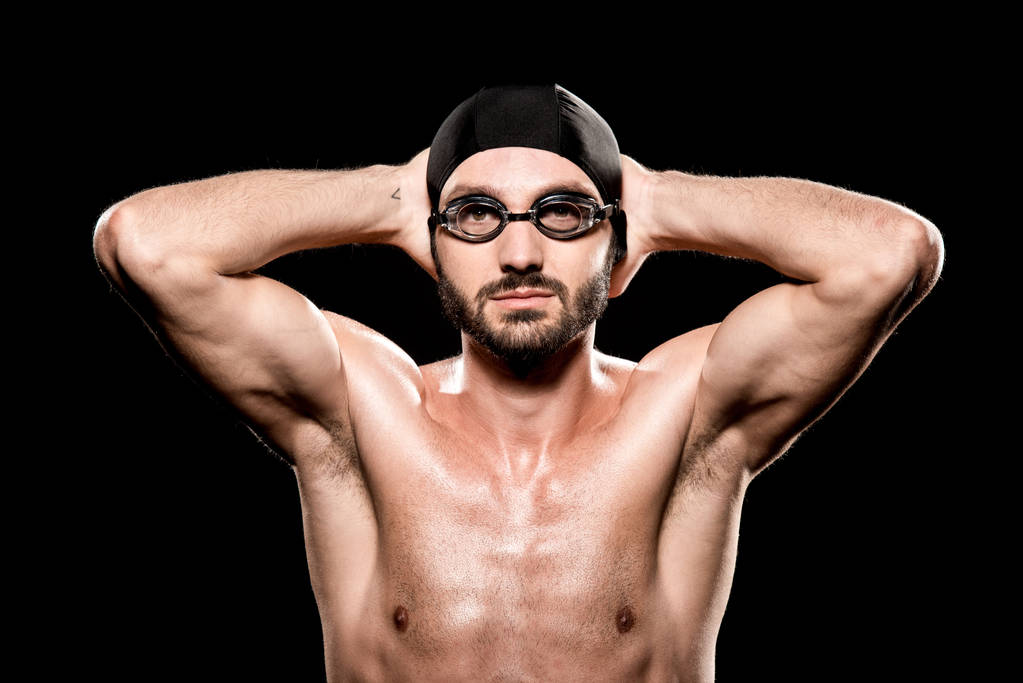 красивый пловец, позирующий в плавательной шапке и очках, изолированных на черном
  - Фото, изображение