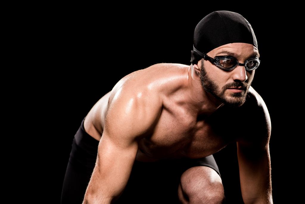 muskulöser Mann mit Brille steht in Startposition isoliert auf schwarz   - Foto, Bild
