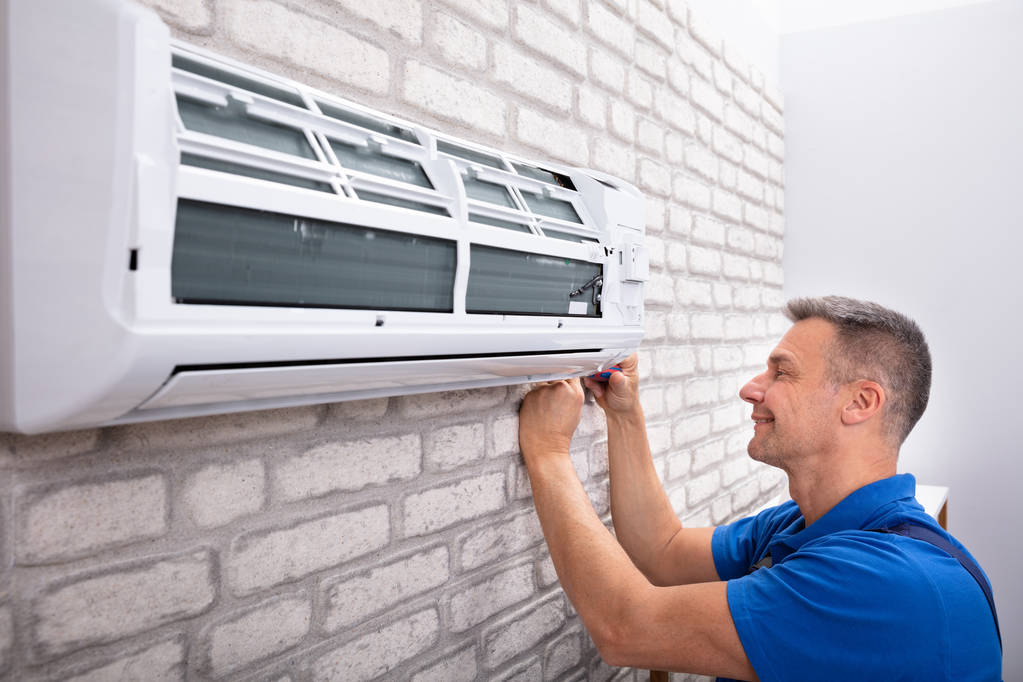 Ältere männliche Techniker Befestigung Klimaanlage mit Schraubenzieher - Foto, Bild