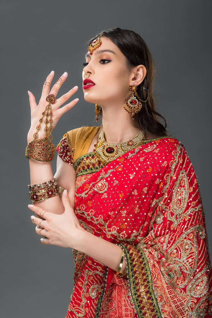 indian woman gesturing in traditional sari and accessories, isolated on grey  - Photo, Image