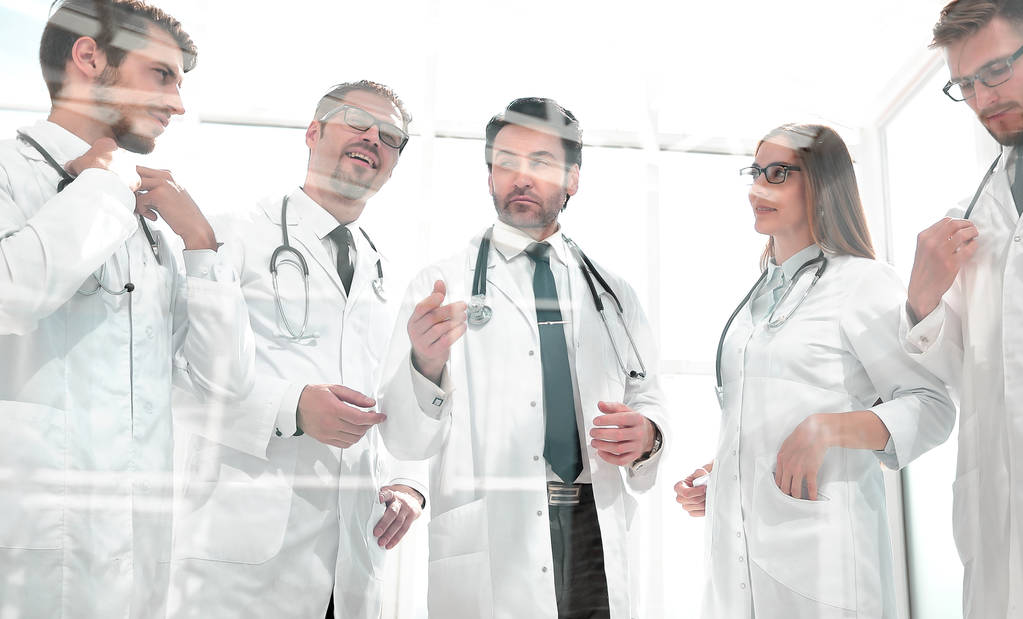 przez szkło. grupę lekarzy stoi w biurze - Zdjęcie, obraz