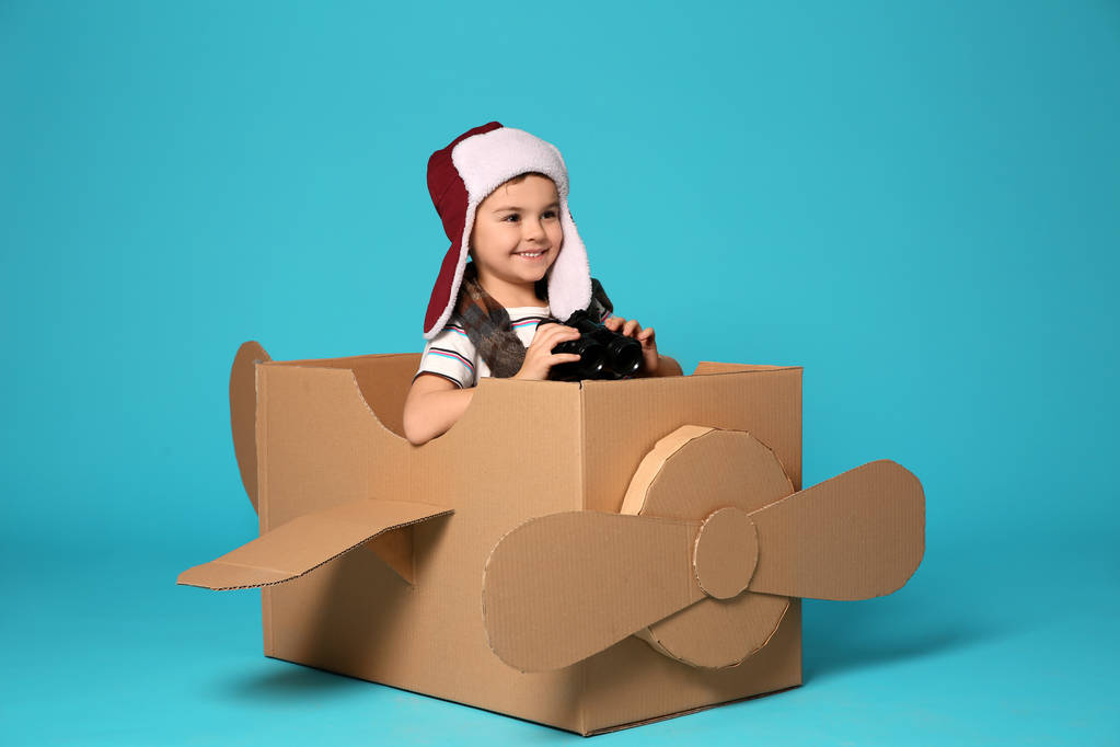 Cute little boy playing with cardboard airplane on white background - Photo, Image