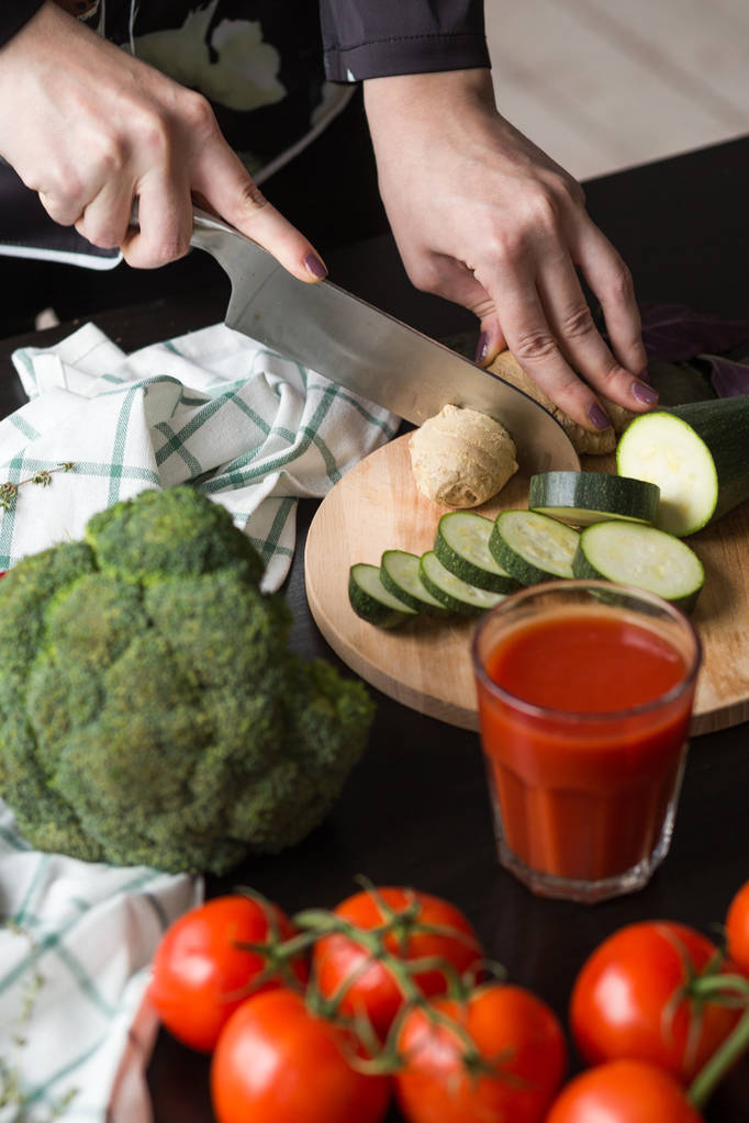 Mädchen schneidet Gemüse mit Messer in der Küche. Frontansicht - Foto, Bild