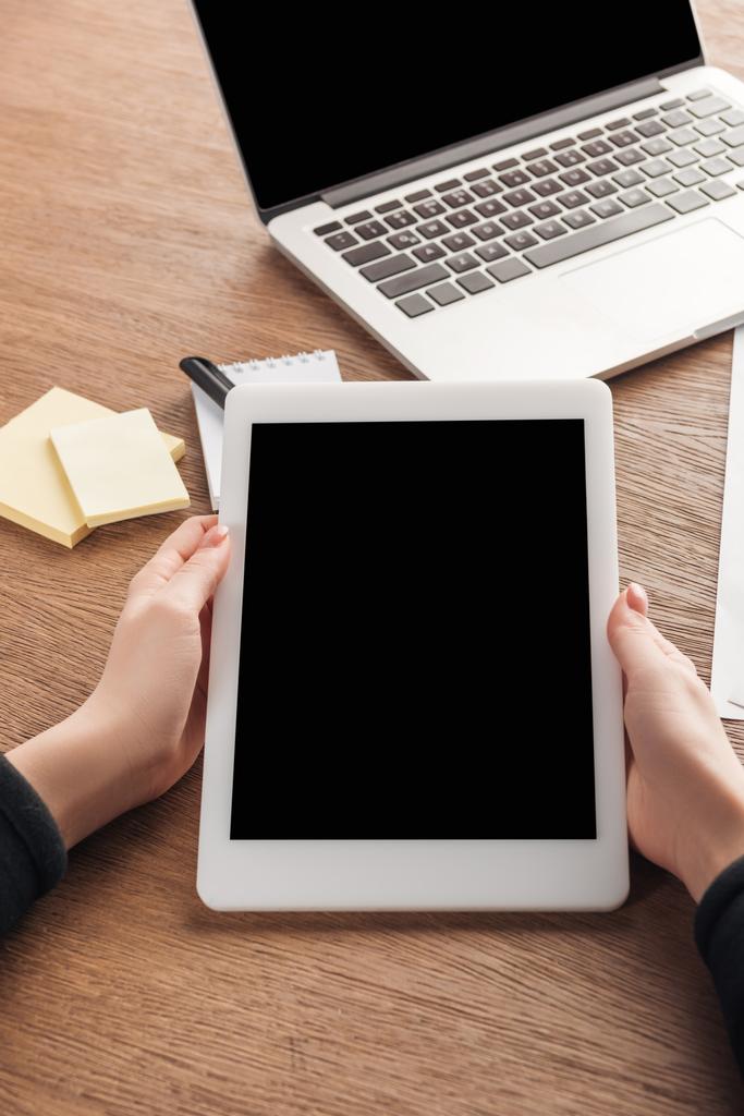 Vista parcial da mulher usando tablet digital com tela em branco no local de trabalho
 - Foto, Imagem