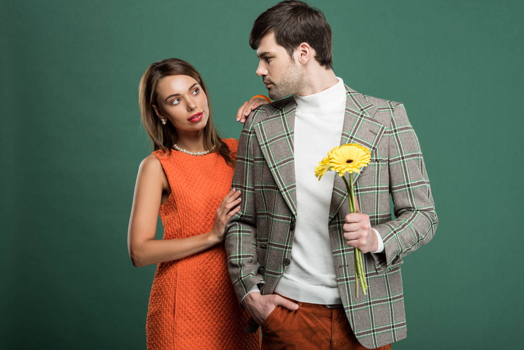 bella donna che abbraccia l'uomo in abiti vintage con fiori isolati sul verde
 - Foto, immagini