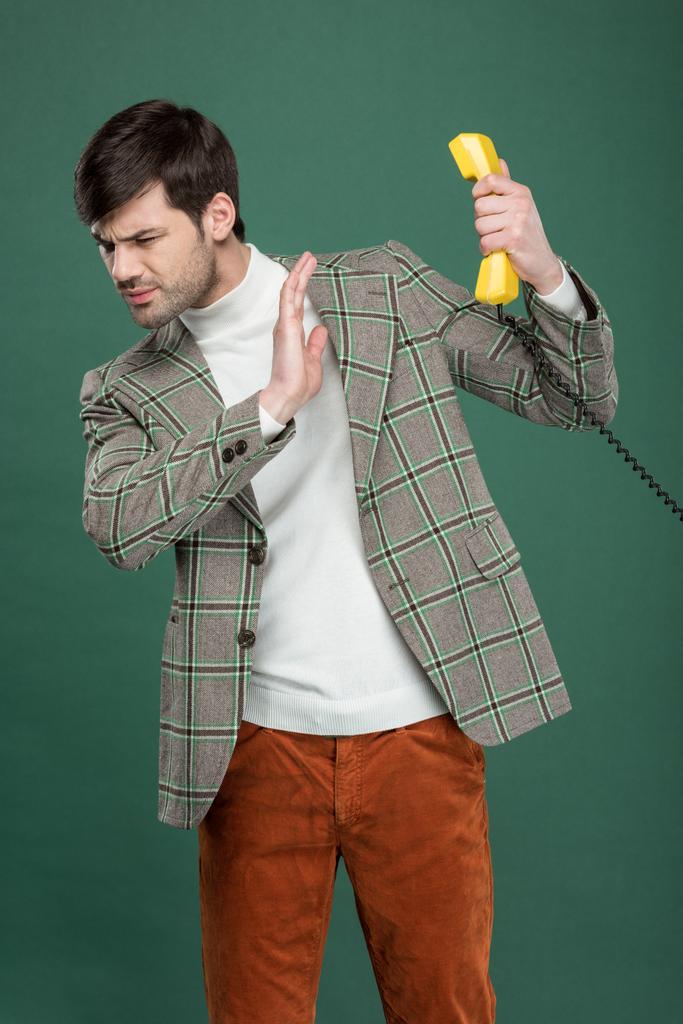 δυσαρεστημένοι όμορφος άνδρας στο vintage ρούχα αρνούμενη τηλεφώνημα και χειρονομίες με το χέρι που απομονώνονται σε πράσινο - Φωτογραφία, εικόνα