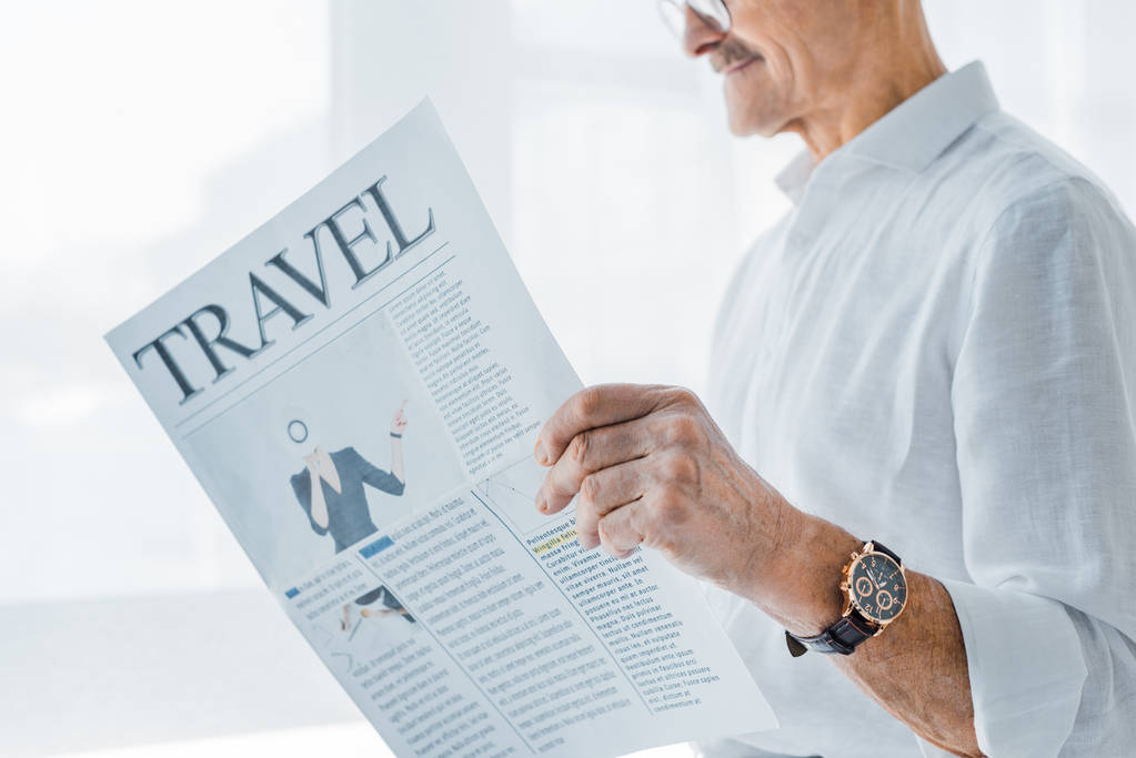 vista ritagliata di anziano uomo lettura giornale di viaggio a casa
 - Foto, immagini