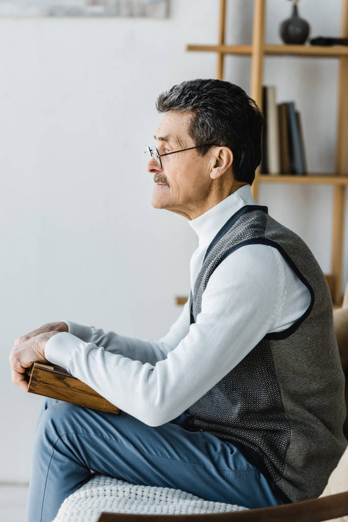 bývalý muž v brýlích doma drží šachovnice - Fotografie, Obrázek
