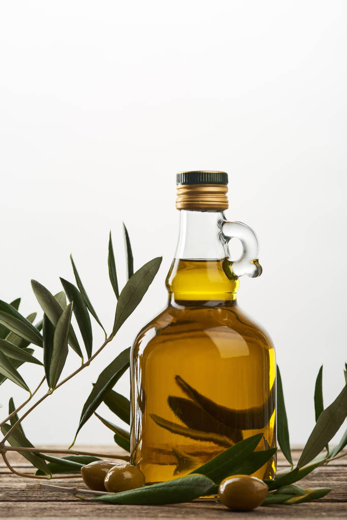 oil tree branch and bottle of oil  isolated on grey  - Photo, Image