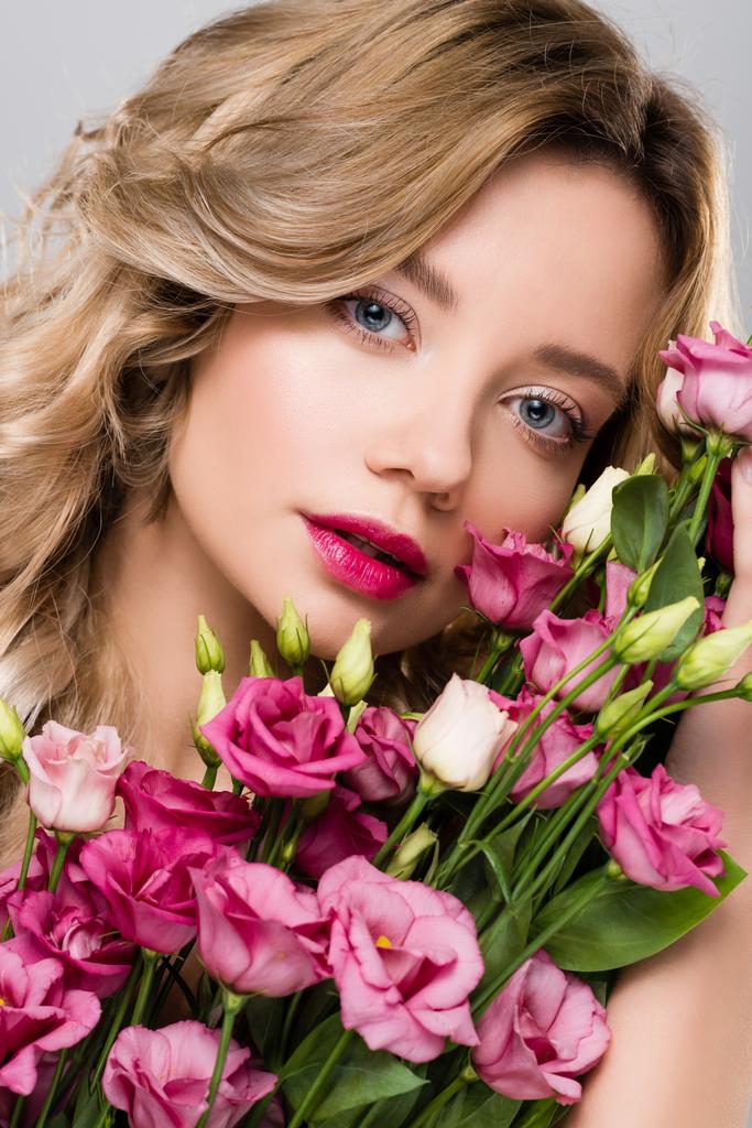beautiful blonde woman posing with spring Eustoma flowers bouquet - Photo, Image