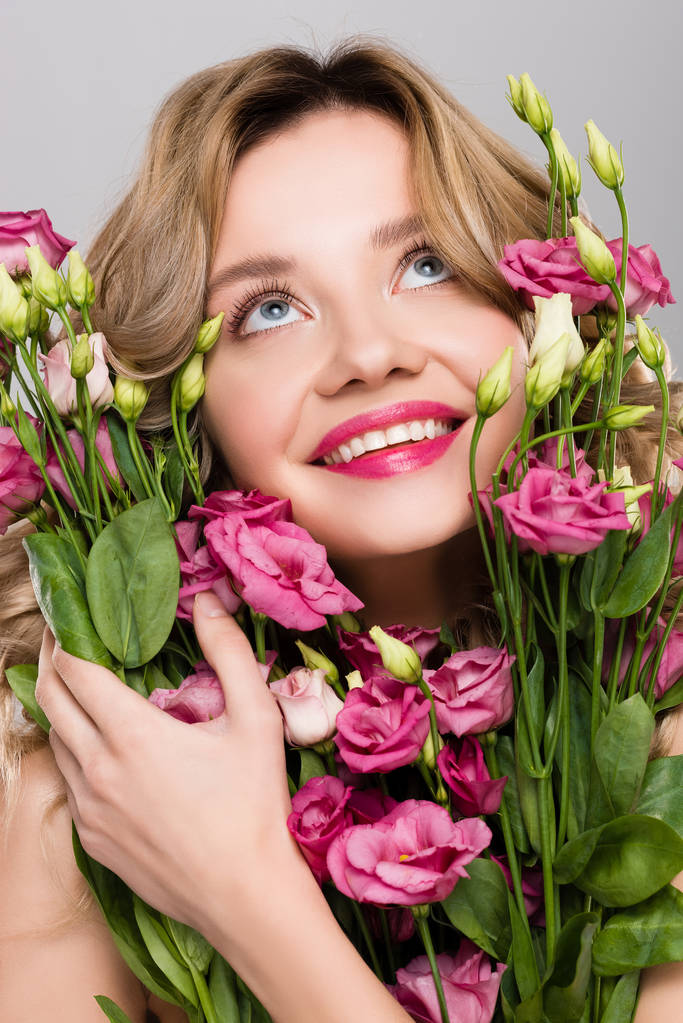 nu souriant printemps jeune femme tenant bouquet de fleurs d'Eustoma isolé sur gris
 - Photo, image