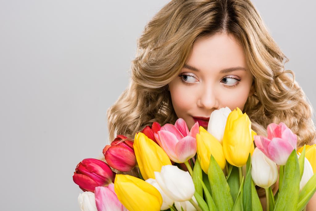 giovane bella donna primaverile tenendo bouquet di tulipani colorati isolati su grigio
  - Foto, immagini