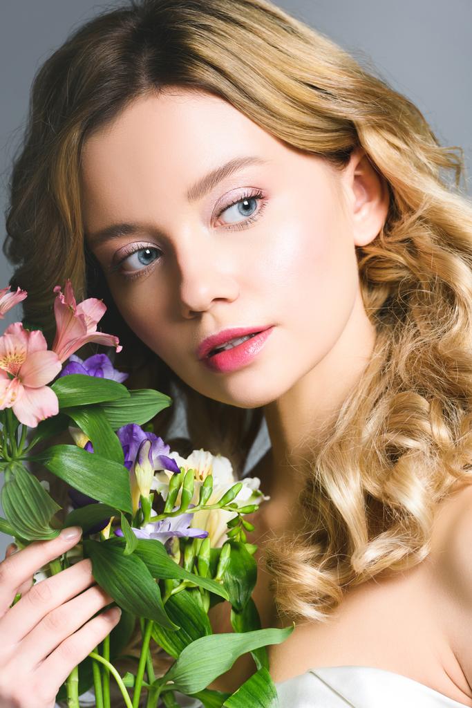 surpresa loira jovem segurando flores na mão
 - Foto, Imagem