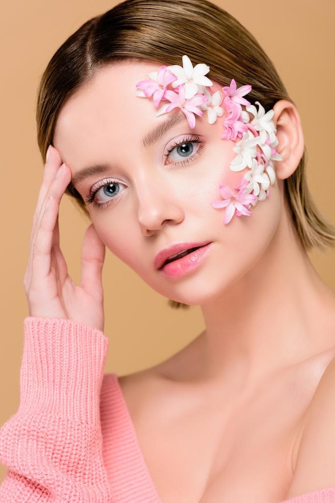beautiful woman with flowers on face looking at camera isolated on beige - Photo, Image