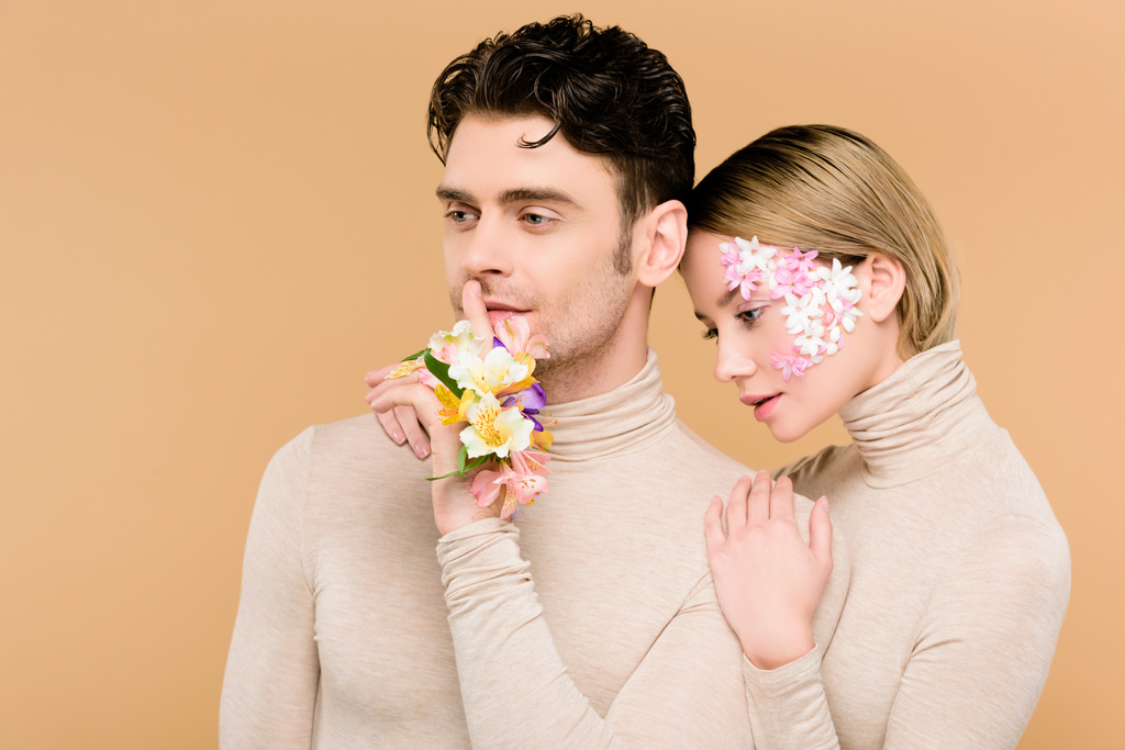 hombre guapo de pie con novia bonita y mostrando signo de silencio aislado en beige
  - Foto, imagen