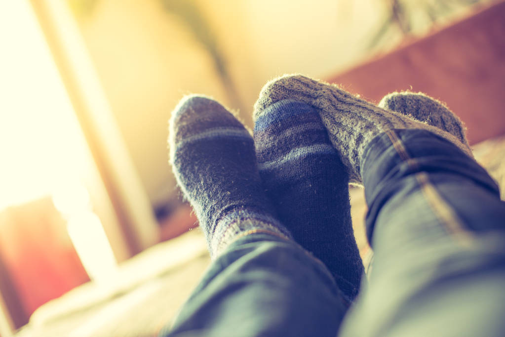 Piedi con calzini di lana in inverno: la coppia si rilassa sul divano
 - Foto, immagini