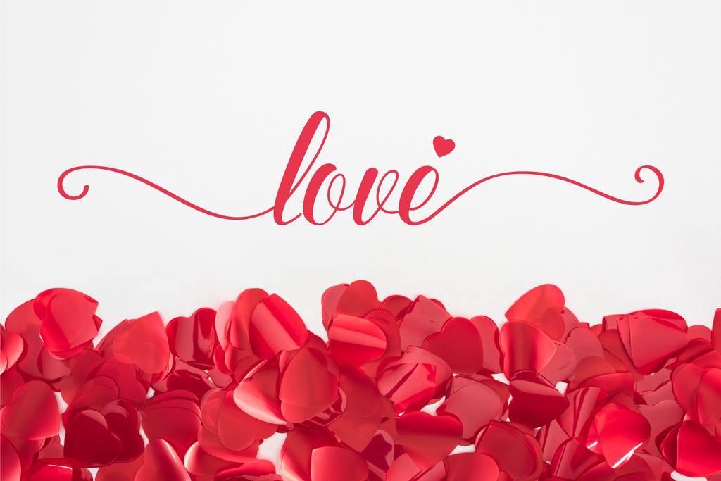 vista de cerca de hermosos pétalos rojos en forma de corazón sobre fondo gris con letras de "amor", concepto de San Valentín
  - Foto, imagen