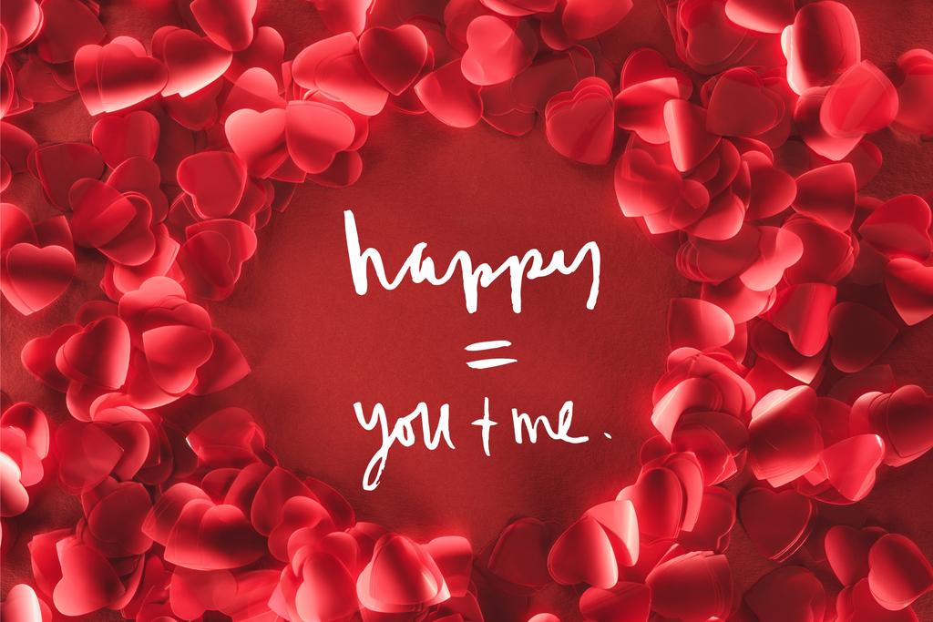 Draufsicht auf schönen runden Rahmen aus dekorativen herzförmigen Blütenblättern auf rotem Hintergrund mit Liebesschrift, Valentinstag-Konzept  - Foto, Bild