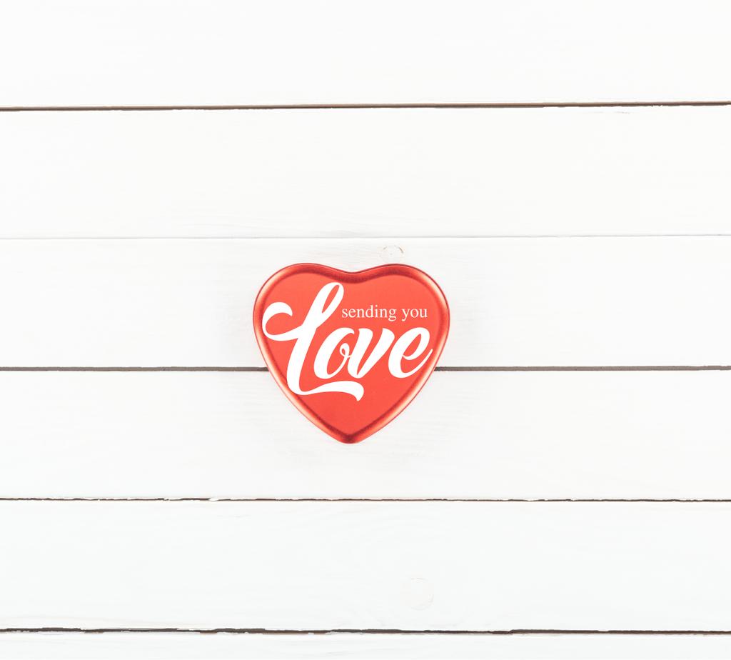 vue du haut de la boîte en forme de coeur rouge avec lettrage "t'envoyer de l'amour" sur fond blanc en bois, concept de Saint Valentin
  - Photo, image