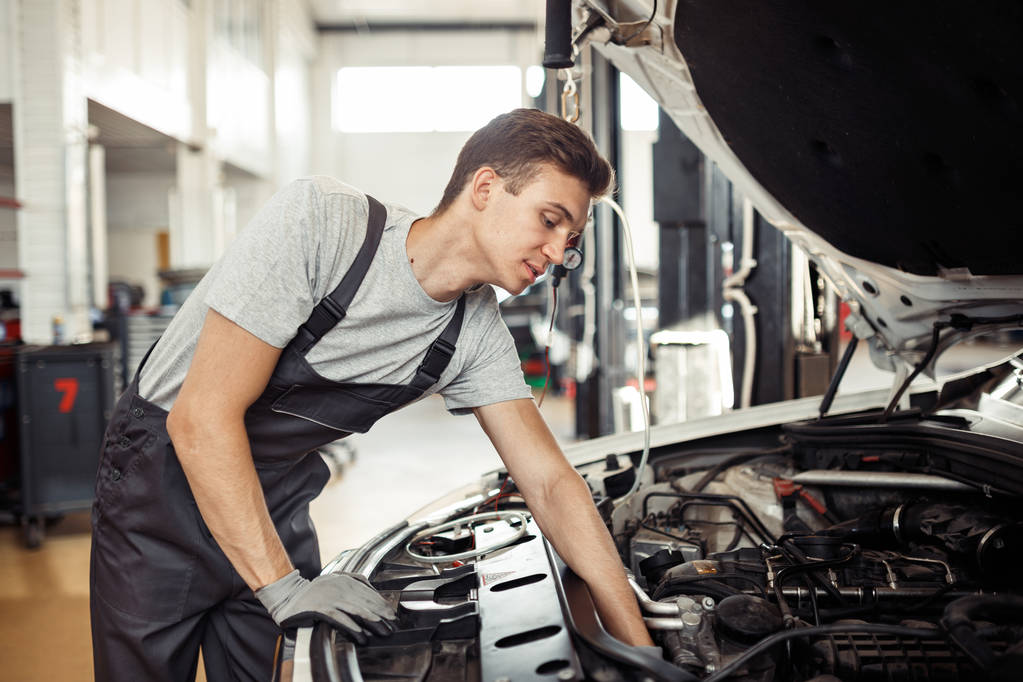 Mechanik naprawia samochód o konserwacji usługi i pojazd samochód - Zdjęcie, obraz